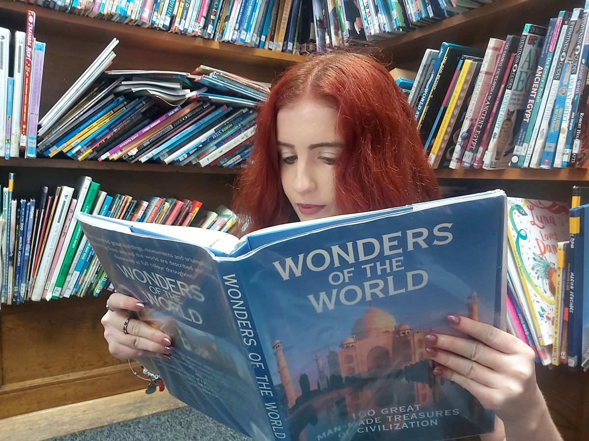 Laura reading world wonders books at Glebe Farm Community Hub children's and teens library